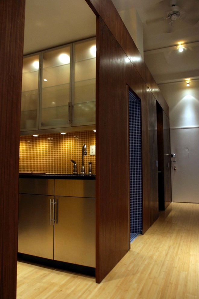 Foto de recibidores y pasillos modernos de tamaño medio con paredes beige, suelo de madera clara y suelo beige