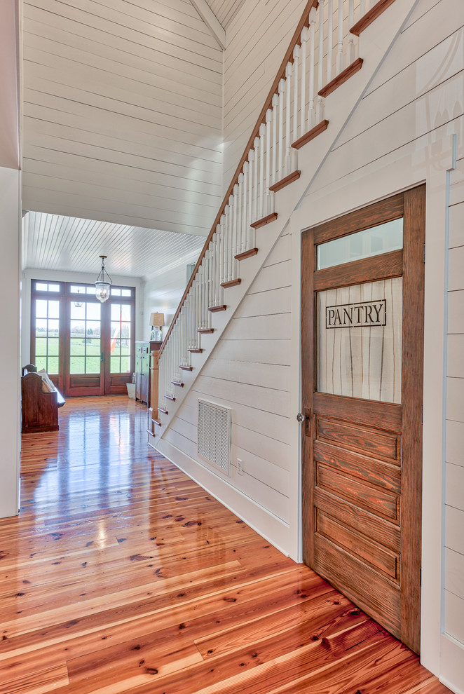 Esempio di un ingresso o corridoio country di medie dimensioni con pareti bianche e pavimento in legno massello medio