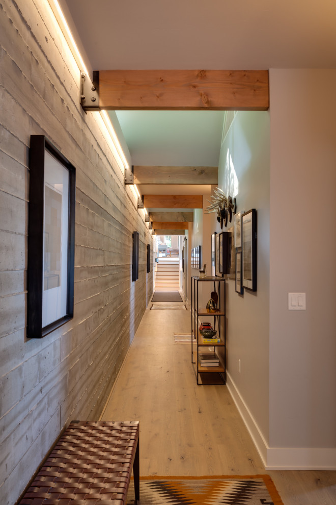 Ejemplo de recibidores y pasillos modernos extra grandes con paredes grises, suelo de madera clara y suelo marrón