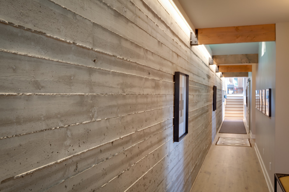 Immagine di un ampio ingresso o corridoio minimalista con pareti grigie, parquet chiaro e pavimento marrone