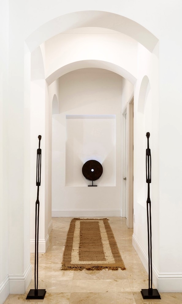 Exemple d'un couloir tendance de taille moyenne avec un mur blanc, un sol en marbre et un sol beige.