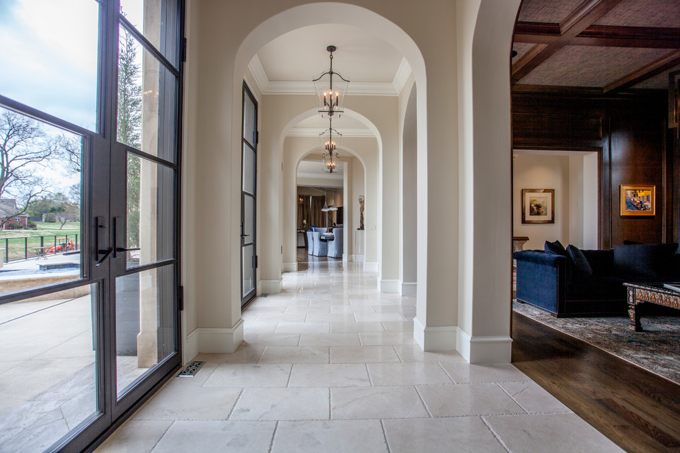 Immagine di un grande ingresso o corridoio mediterraneo con pareti beige, pavimento in travertino e pavimento beige