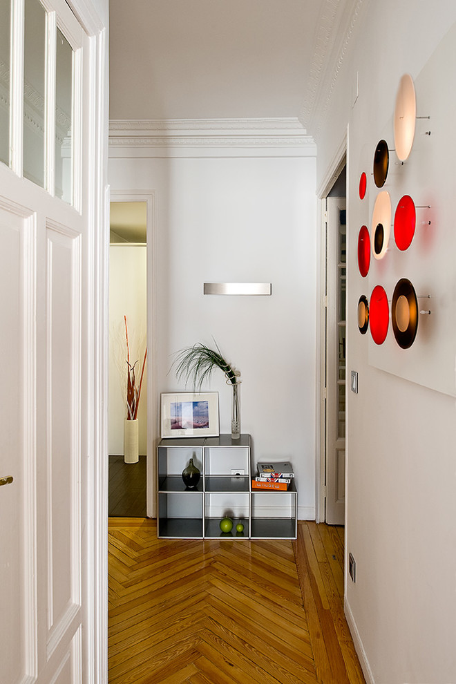 Idee per un ingresso o corridoio minimal di medie dimensioni con pareti bianche e pavimento in legno massello medio