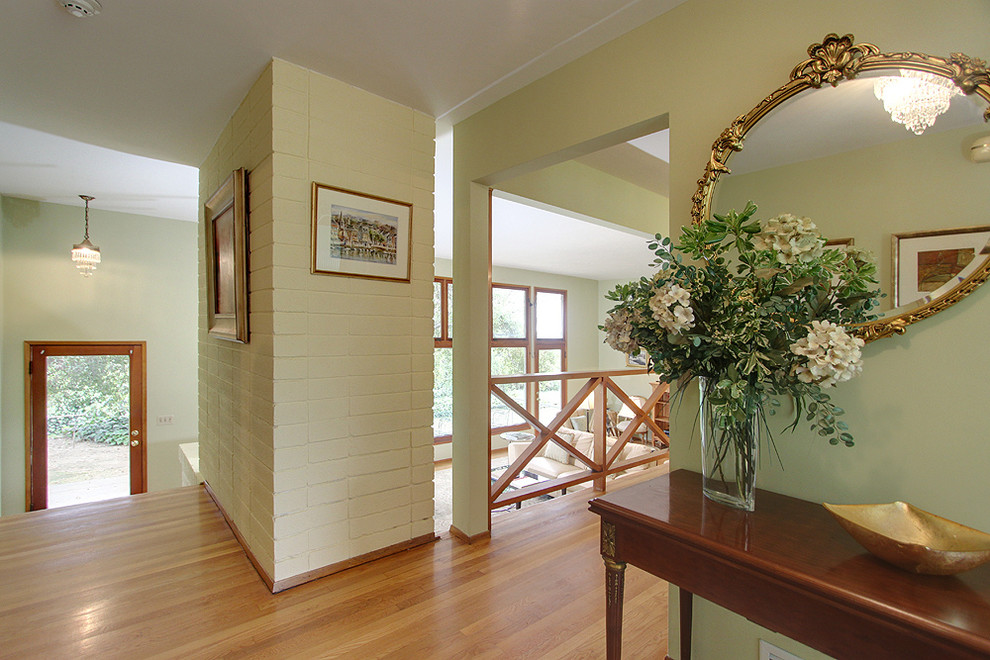 Inspiration pour un couloir traditionnel de taille moyenne avec un mur vert et un sol en bois brun.