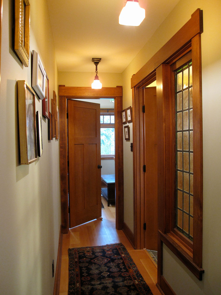 Réalisation d'un couloir craftsman de taille moyenne avec un mur vert, un sol en bois brun et un sol marron.