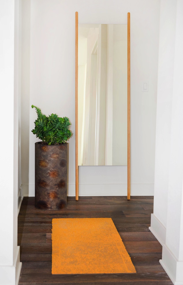 Idee per un piccolo ingresso o corridoio minimal con pareti bianche, pavimento in legno massello medio e pavimento grigio