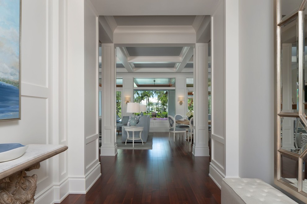 Ejemplo de recibidores y pasillos tropicales de tamaño medio con paredes blancas, suelo de madera en tonos medios y suelo marrón