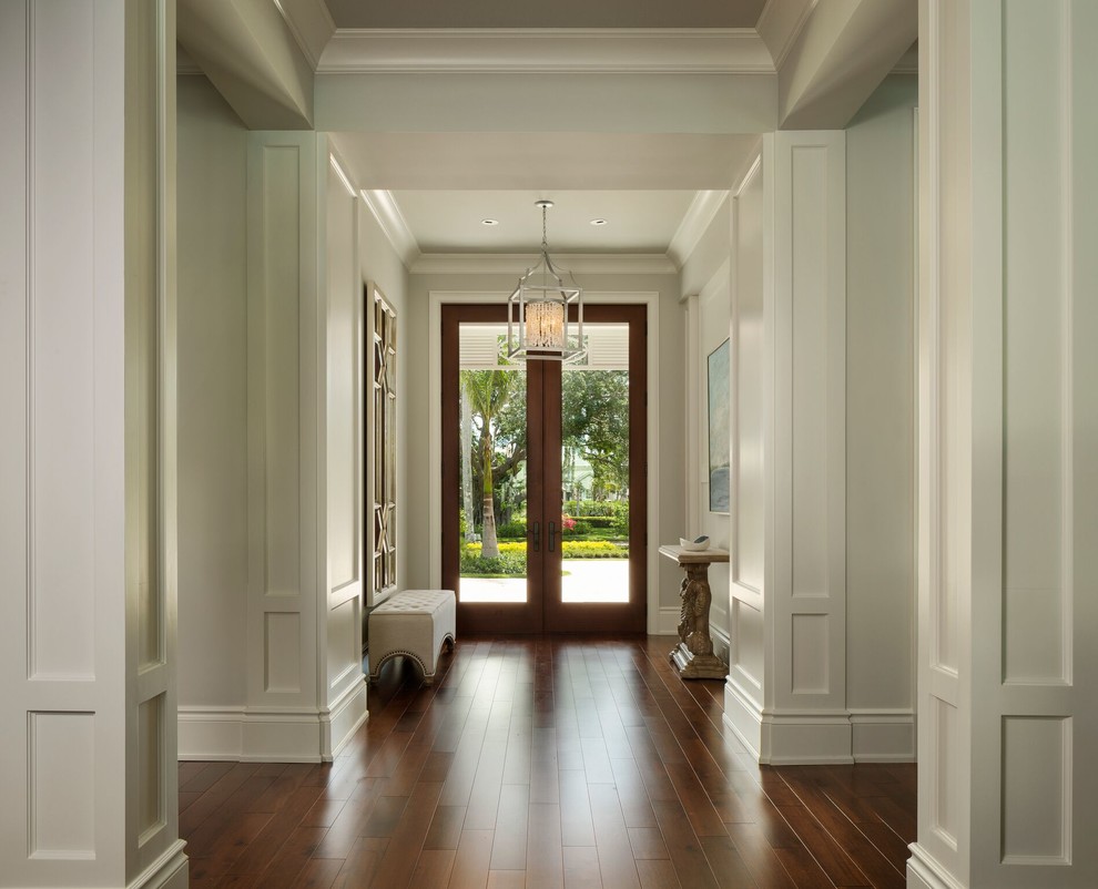 Modelo de recibidores y pasillos tradicionales renovados grandes con paredes blancas, suelo de madera en tonos medios y suelo marrón