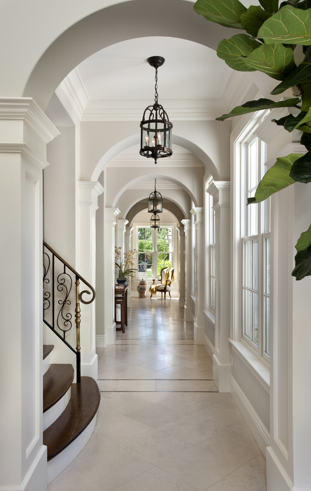 Ispirazione per un ingresso o corridoio tradizionale con pareti bianche e pavimento in travertino