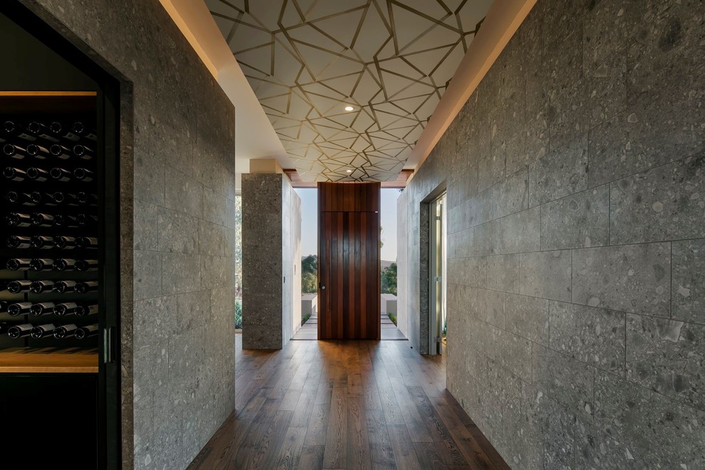 Idées déco pour un grand couloir contemporain avec un mur gris, parquet foncé et un sol marron.
