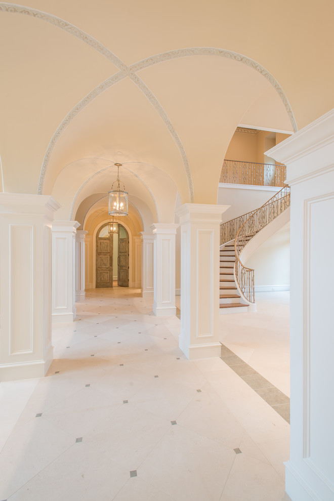 Example of a large tuscan limestone floor and white floor hallway design in Dallas with beige walls