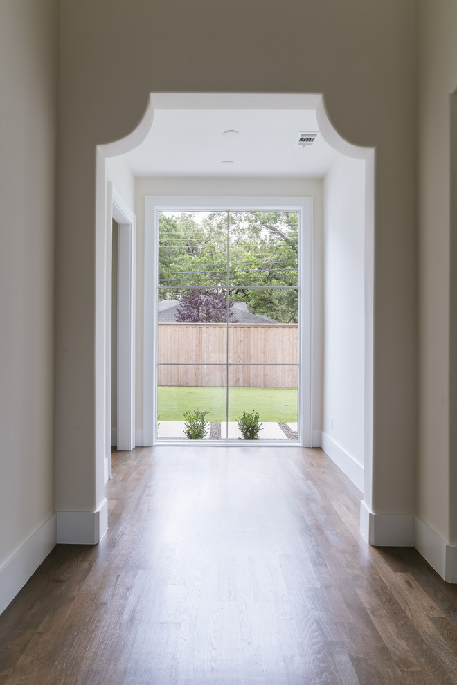 Example of a huge transitional medium tone wood floor and brown floor hallway design in Dallas with white walls