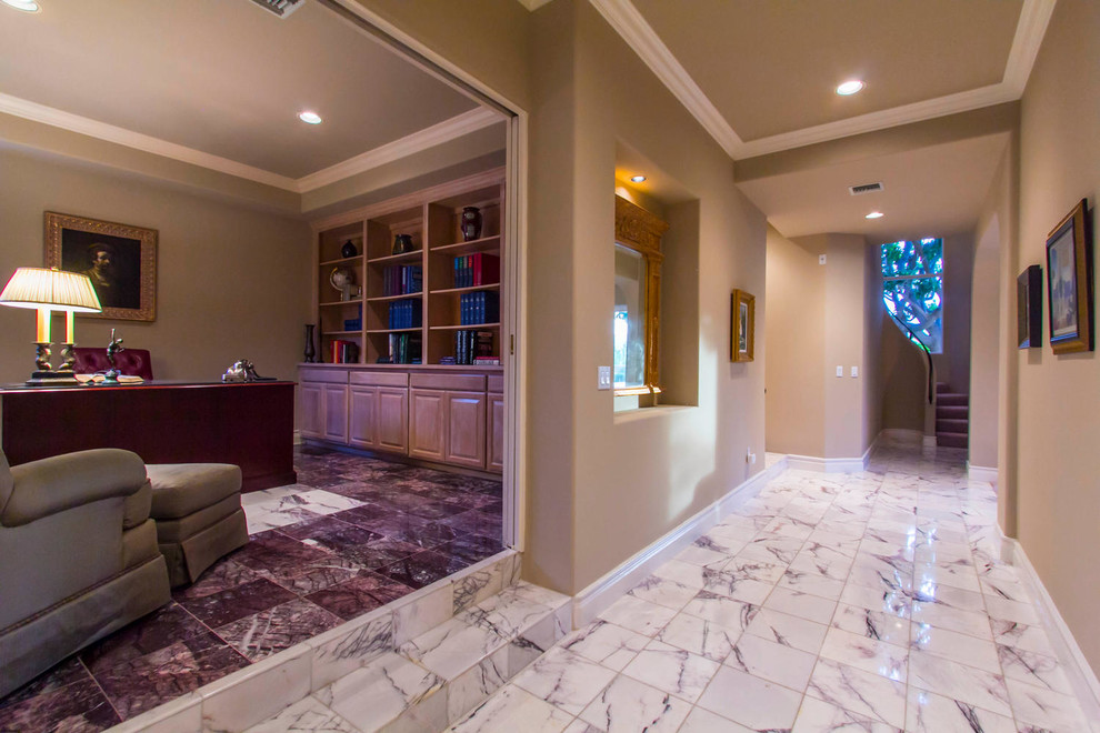 Example of a mid-sized trendy marble floor and white floor hallway design in Los Angeles with beige walls