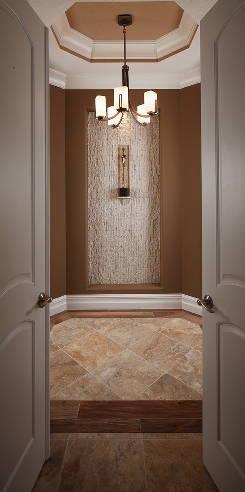 Cette image montre un couloir traditionnel avec un mur beige, un sol en calcaire et un sol beige.