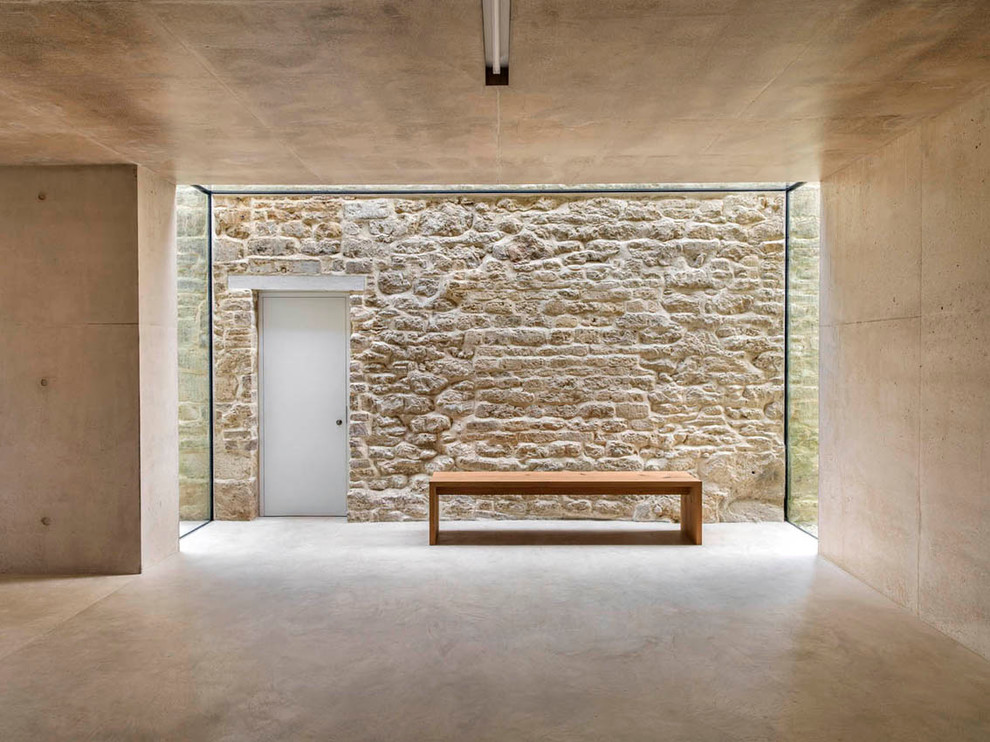 Ispirazione per un ingresso o corridoio minimalista con pavimento in cemento