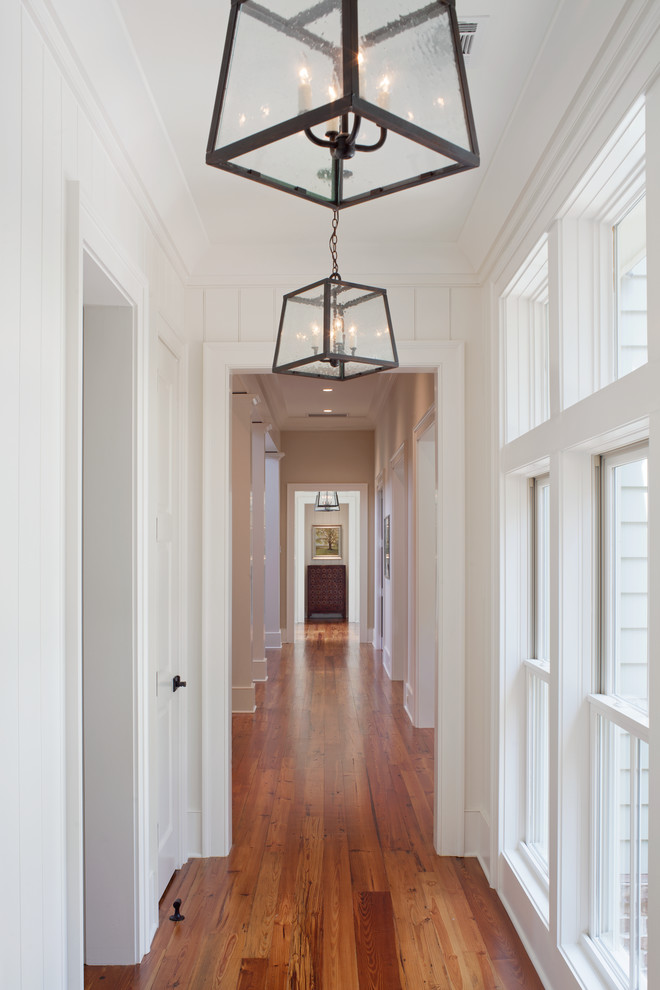 На фото: коридор в классическом стиле с белыми стенами и светлым паркетным полом с