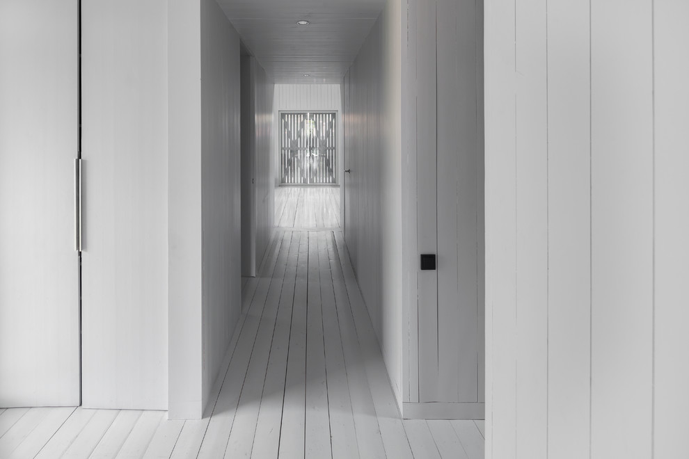 Idee per un ingresso o corridoio nordico con pareti bianche e pavimento in legno verniciato