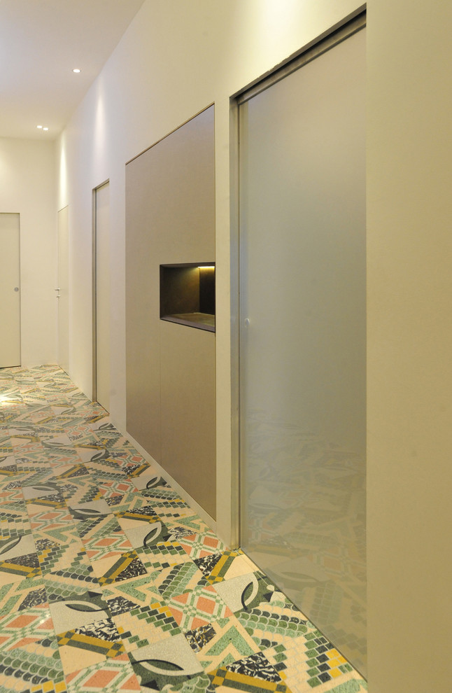 Ispirazione per un ingresso o corridoio design con pareti bianche e pavimento con piastrelle in ceramica