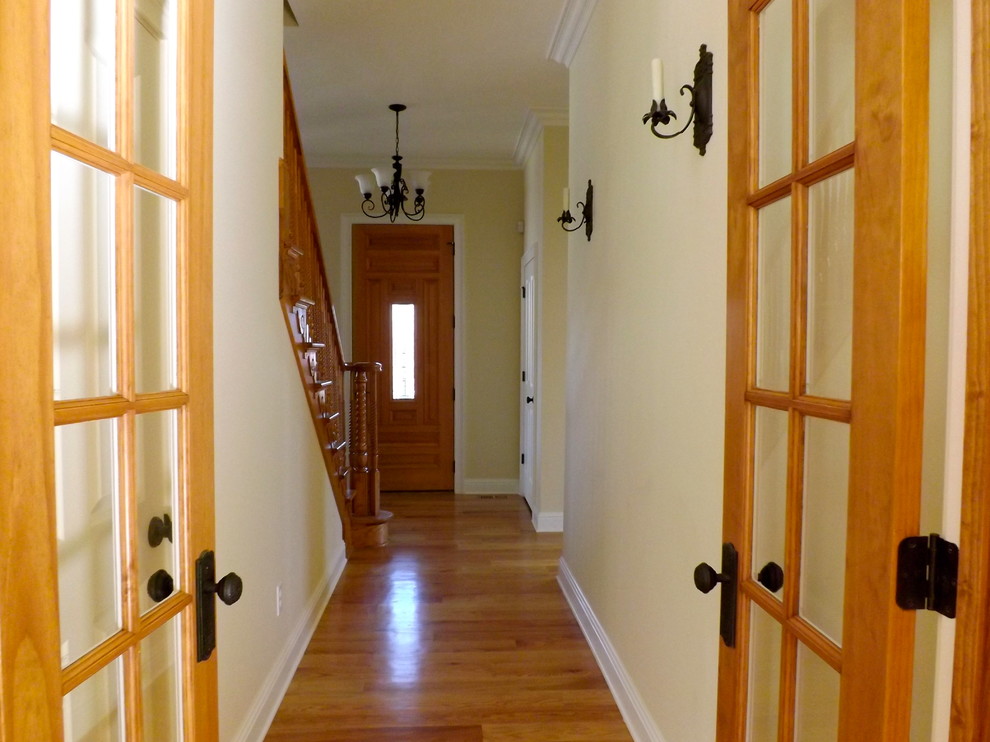 Ejemplo de recibidores y pasillos vintage de tamaño medio con paredes amarillas y suelo de madera en tonos medios