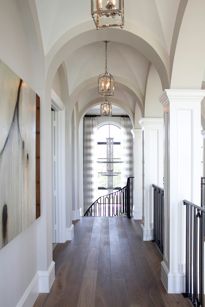 На фото: коридор среднего размера в классическом стиле с белыми стенами и темным паркетным полом с