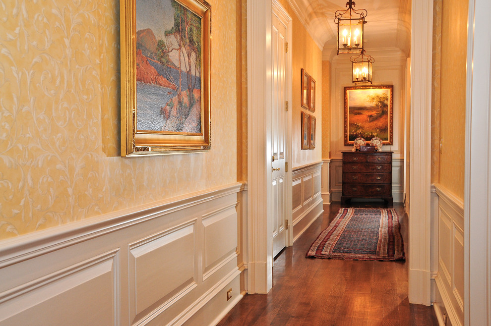 Foto de recibidores y pasillos clásicos grandes con paredes amarillas y suelo de madera en tonos medios