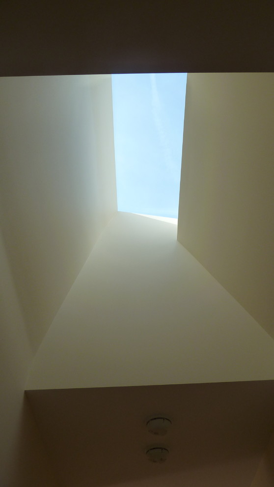 Immagine di un ingresso o corridoio minimal di medie dimensioni con pareti bianche e parquet chiaro