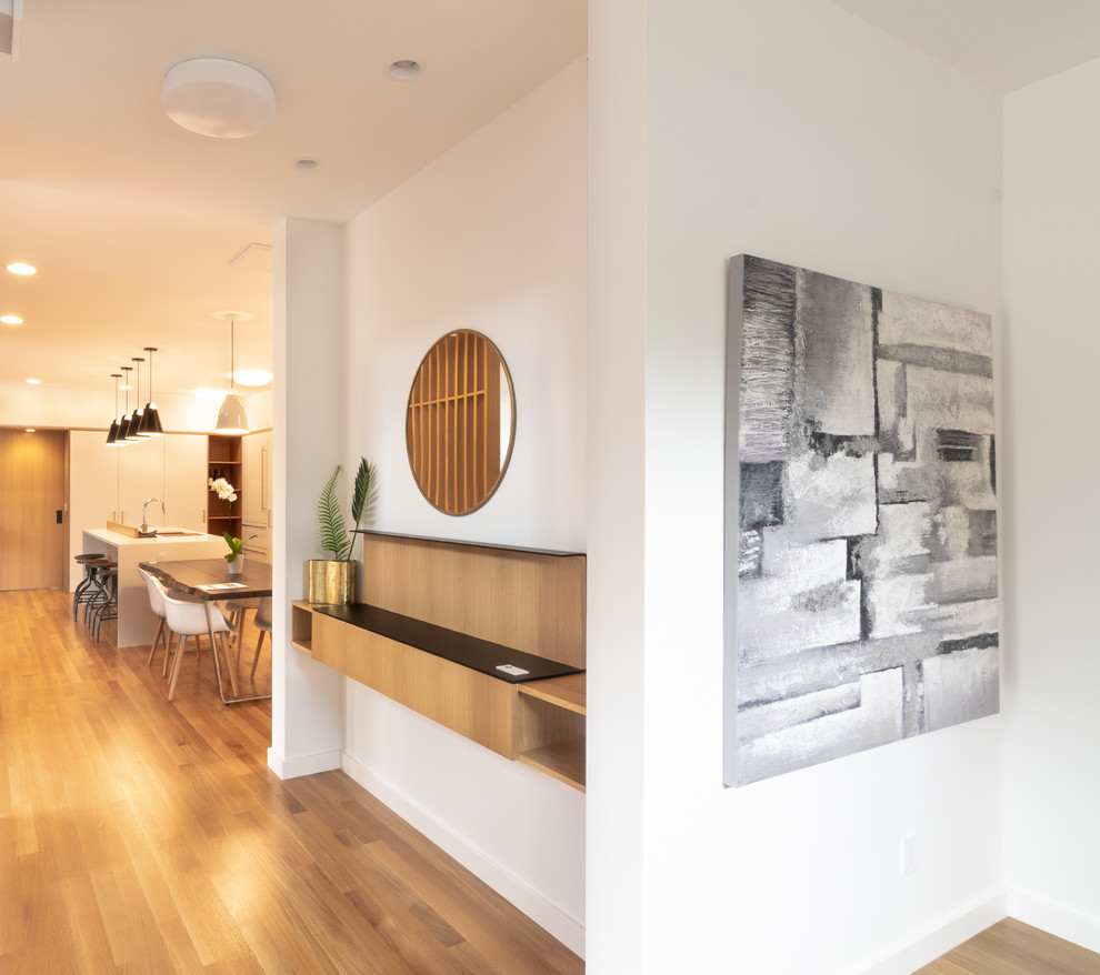 Inspiration for a mid-sized modern medium tone wood floor and brown floor hallway remodel in Seattle with white walls