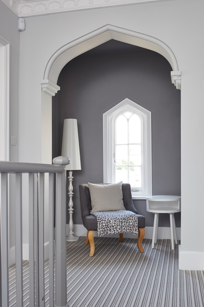 На фото: большой коридор в стиле неоклассика (современная классика) с серыми стенами, ковровым покрытием и разноцветным полом с
