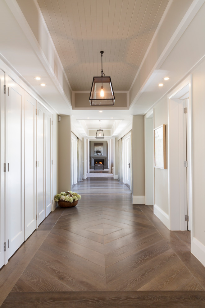 На фото: большой коридор в стиле кантри с паркетным полом среднего тона, коричневым полом и кессонным потолком