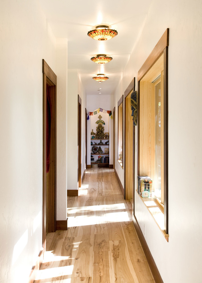 Modelo de recibidores y pasillos asiáticos con paredes blancas, suelo de madera en tonos medios y suelo marrón