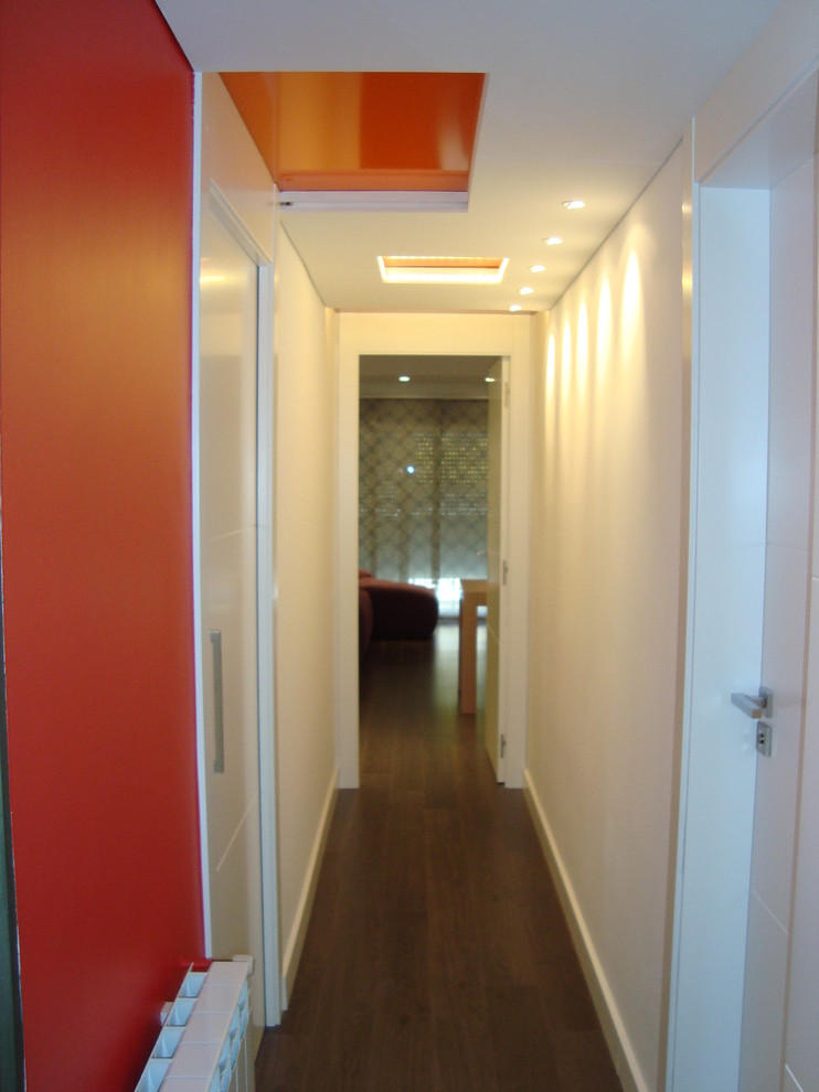 Aménagement d'un petit couloir contemporain avec un mur blanc et parquet foncé.