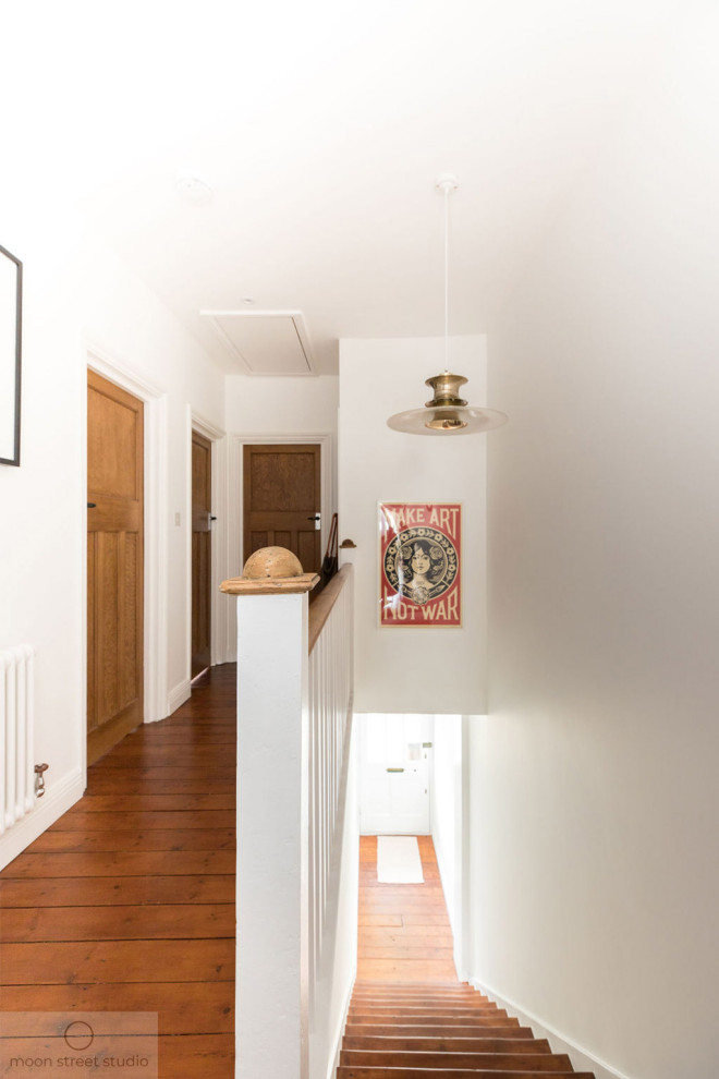 На фото: коридор среднего размера в современном стиле с белыми стенами, паркетным полом среднего тона и коричневым полом с