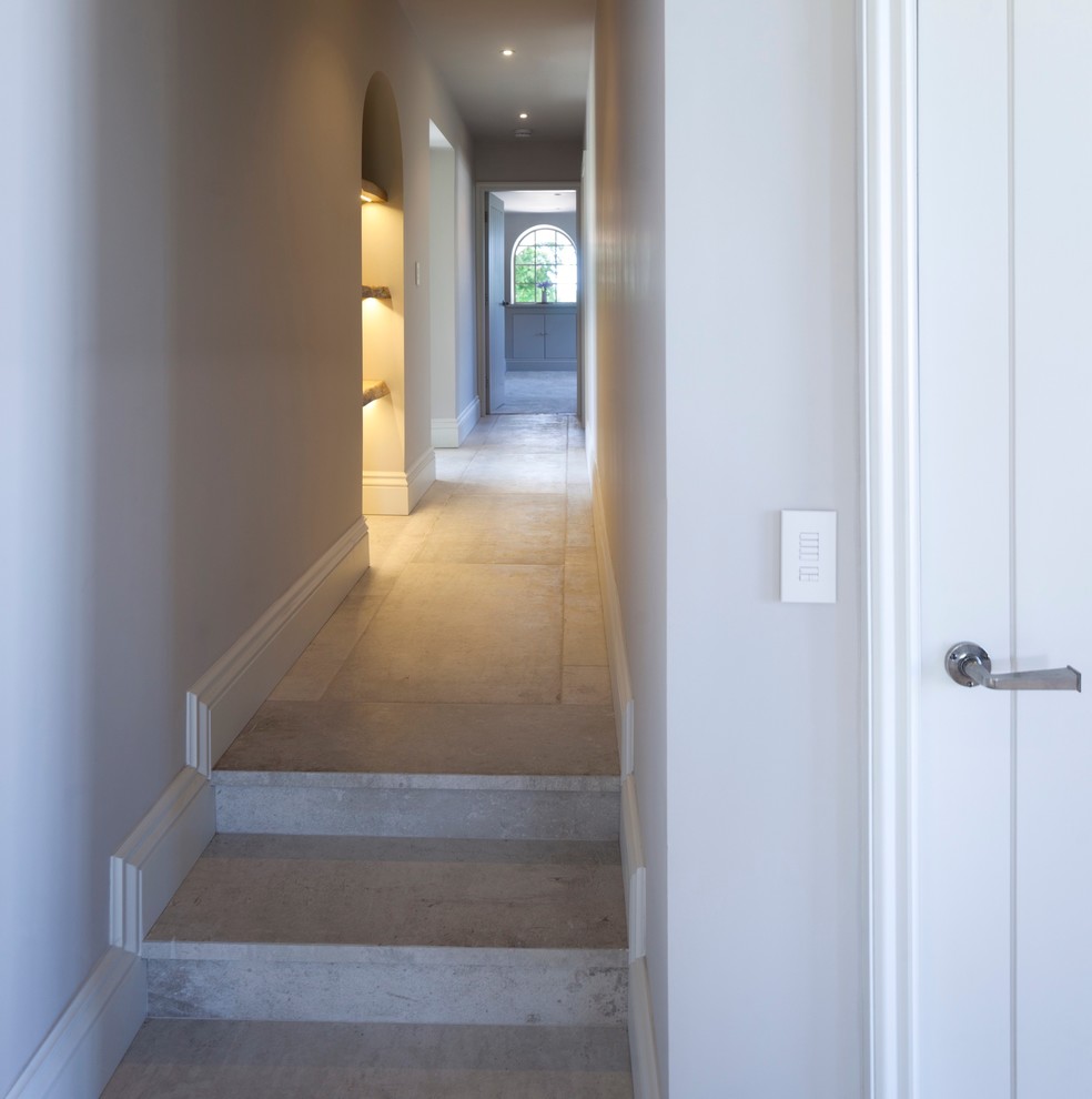 На фото: большой коридор в современном стиле с белыми стенами и полом из керамической плитки с