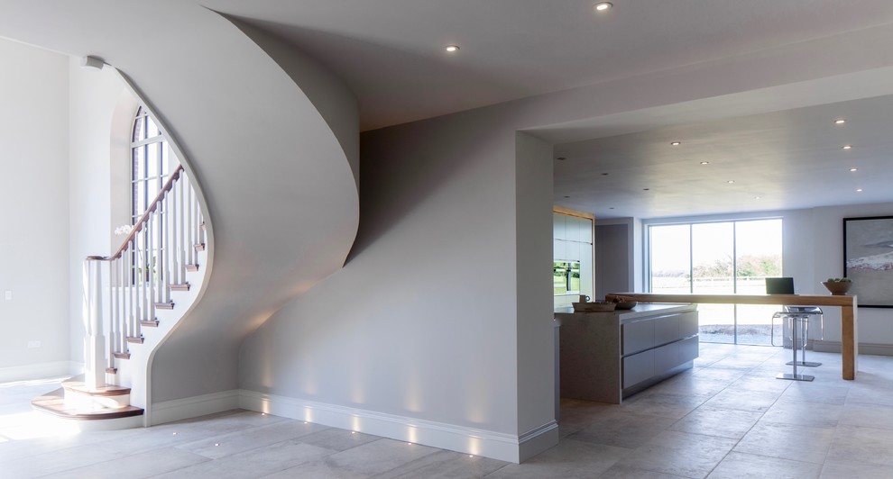 Cette image montre un grand couloir design avec un mur blanc et un sol en carrelage de céramique.