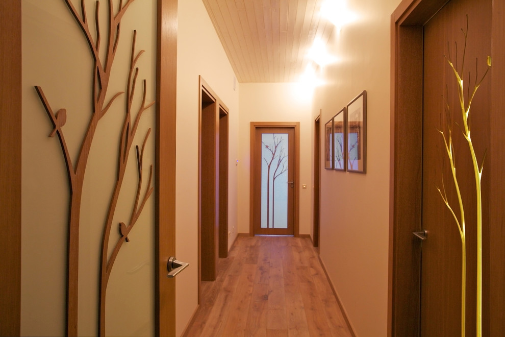 Idéer för en modern hall, med vita väggar och mellanmörkt trägolv
