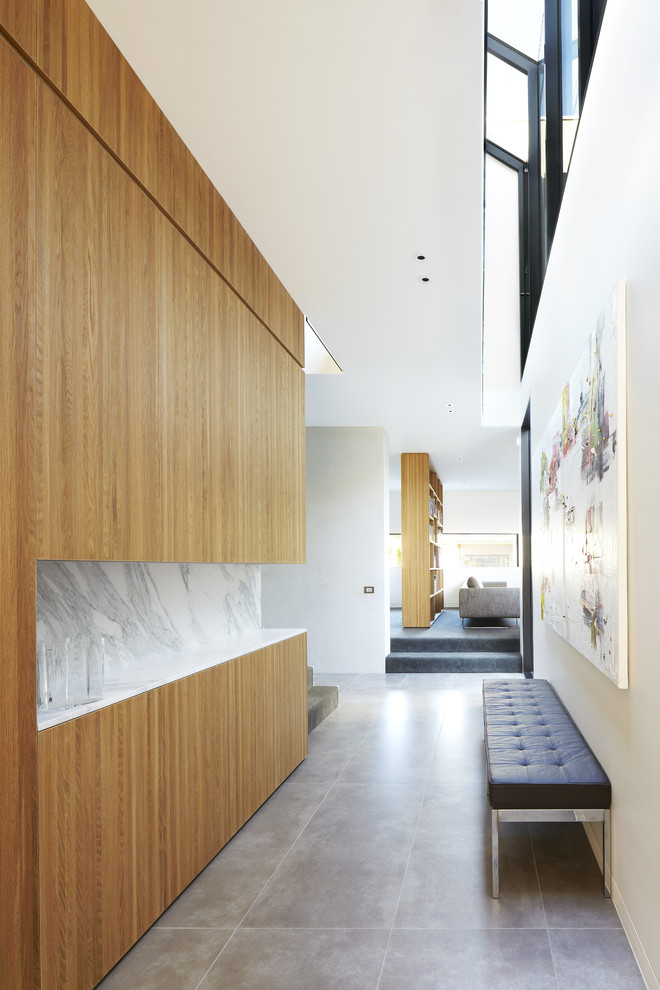 Cette photo montre un couloir tendance de taille moyenne avec un mur blanc et sol en béton ciré.