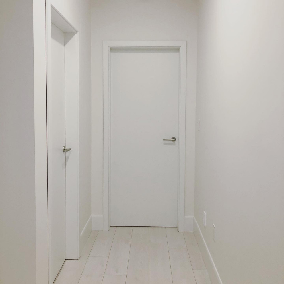 Inspiration for a mid-sized modern vinyl floor and white floor hallway remodel in Toronto with white walls