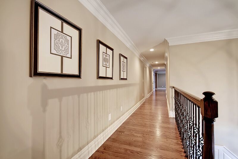 Immagine di un grande ingresso o corridoio classico con pareti beige e pavimento in legno massello medio