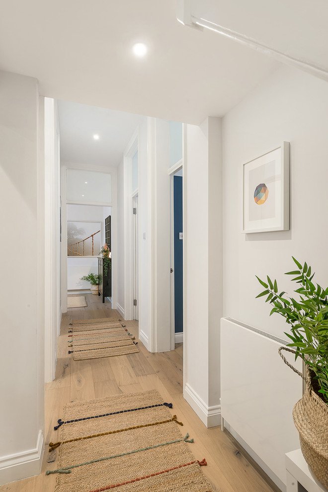 На фото: коридор среднего размера в современном стиле с бежевыми стенами, светлым паркетным полом и коричневым полом с