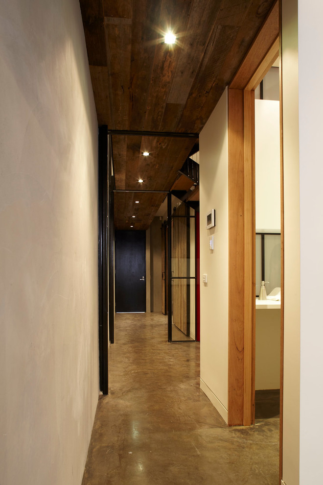 Immagine di un ingresso o corridoio industriale con pareti bianche e pavimento in cemento