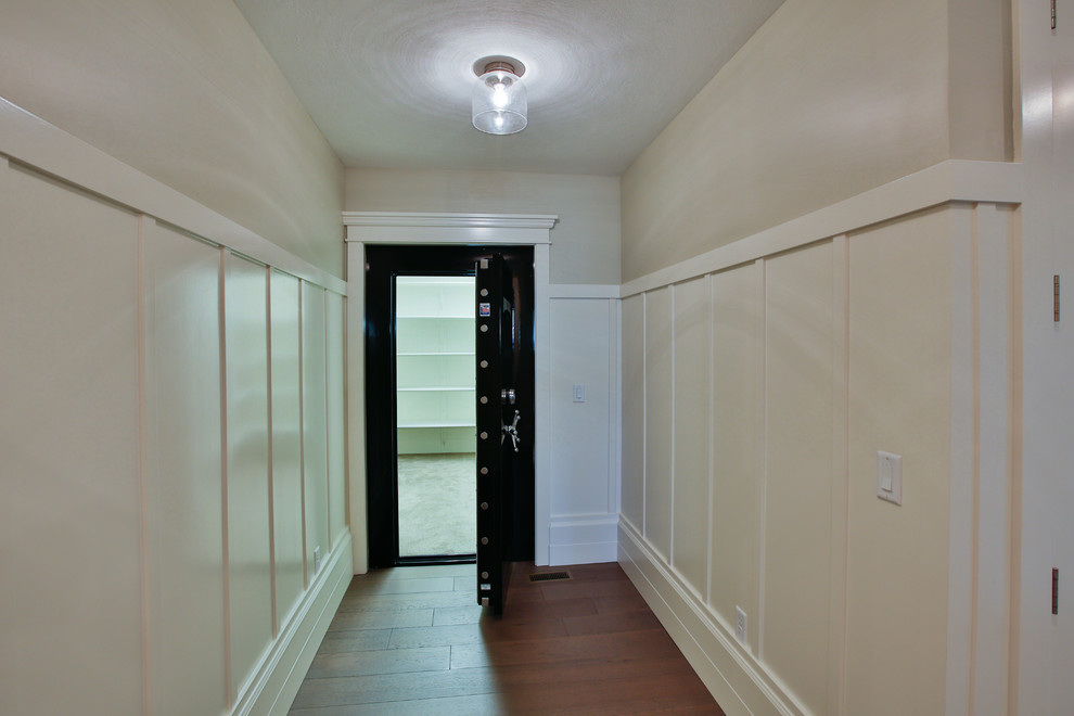 Exemple d'un grand couloir chic avec un mur blanc et un sol en bois brun.