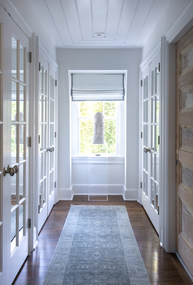 Стильный дизайн: коридор в стиле фьюжн с белыми стенами, паркетным полом среднего тона и коричневым полом - последний тренд