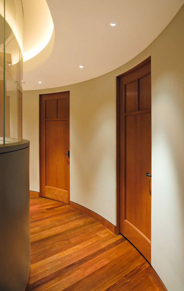 Ejemplo de recibidores y pasillos tradicionales renovados con paredes beige y suelo de madera en tonos medios