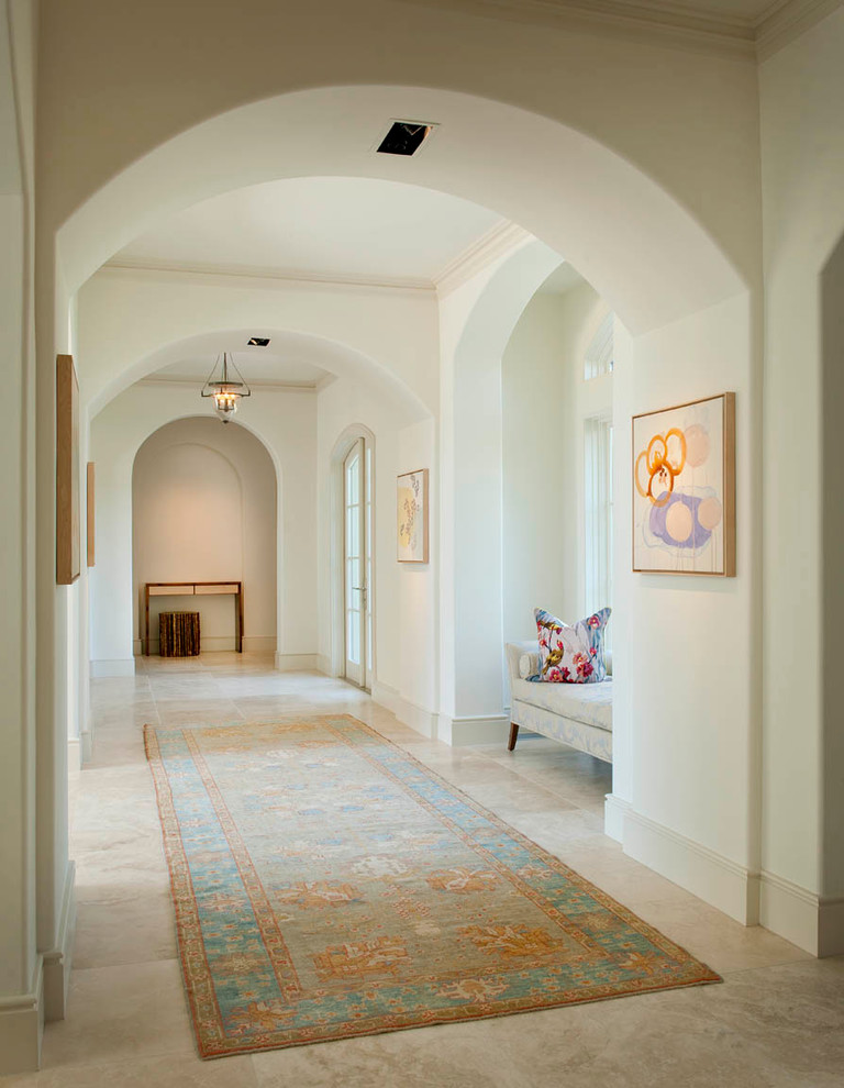 Ejemplo de recibidores y pasillos clásicos grandes con paredes beige, suelo de travertino, suelo beige y iluminación
