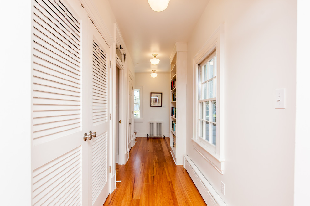 Foto de recibidores y pasillos de estilo americano de tamaño medio con paredes blancas y suelo de madera en tonos medios