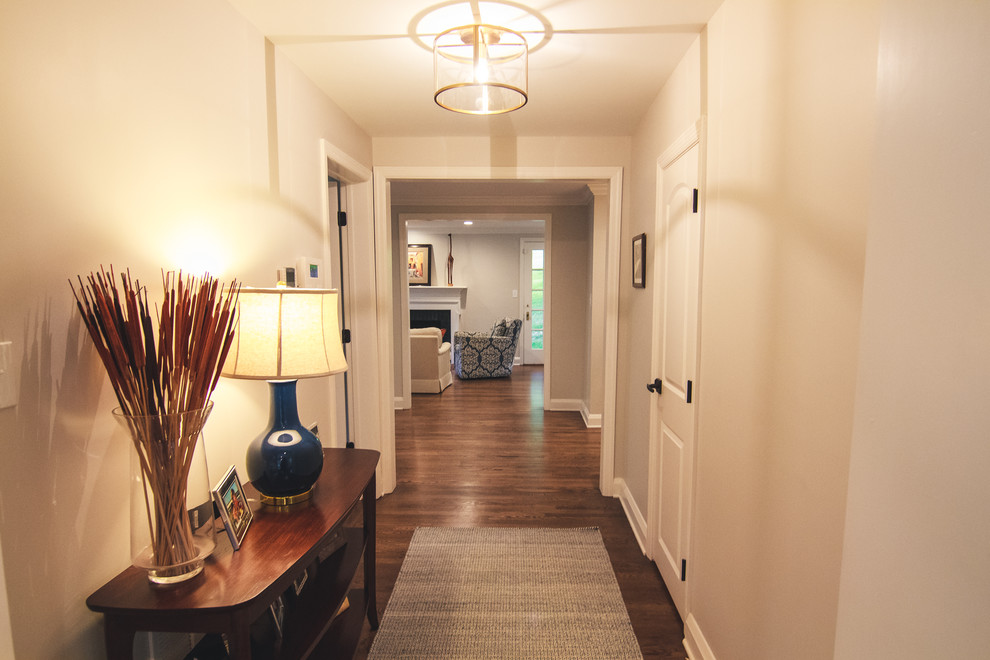 Aménagement d'un couloir classique de taille moyenne avec un mur blanc, un sol en bois brun et un sol marron.