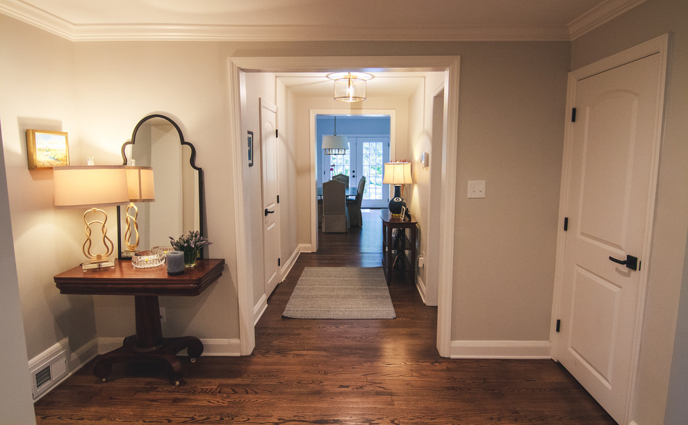 На фото: большой коридор в классическом стиле с бежевыми стенами, паркетным полом среднего тона и коричневым полом с