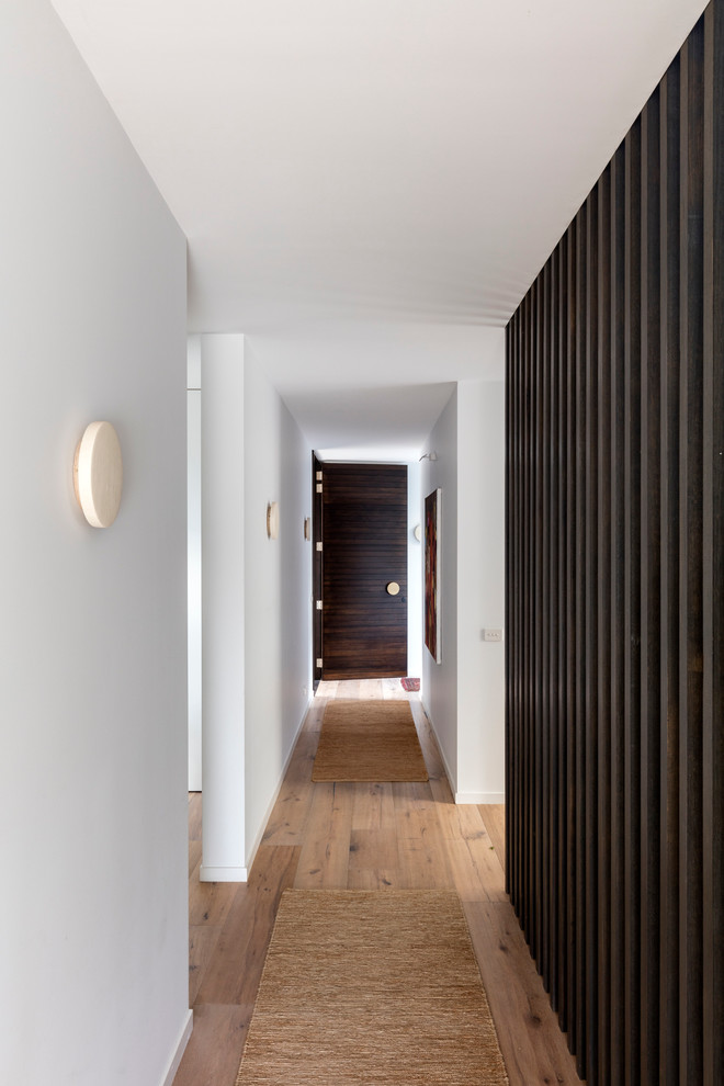 На фото: коридор среднего размера в современном стиле с белыми стенами и светлым паркетным полом с