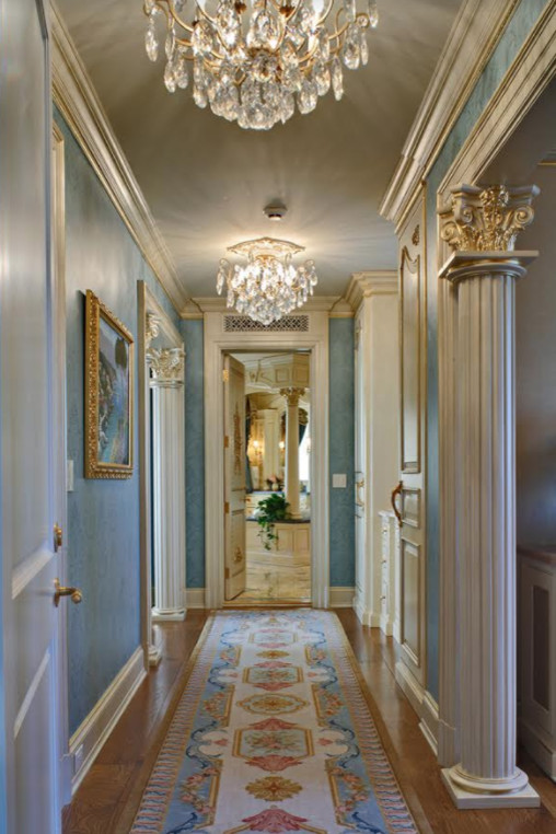Idée de décoration pour un couloir de taille moyenne avec un mur bleu, un sol en bois brun et un sol beige.