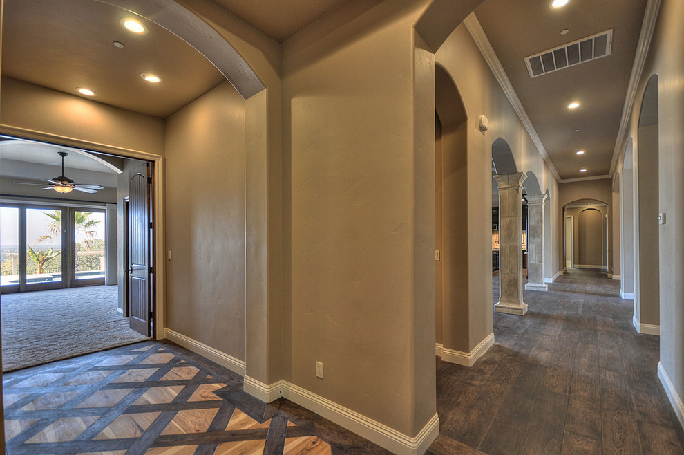 Example of a tuscan dark wood floor hallway design in Other with brown walls